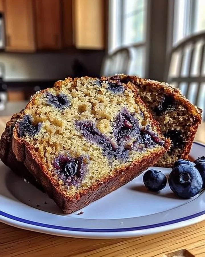 Loaf of freshly baked banana blueberry bread on a cooling rack