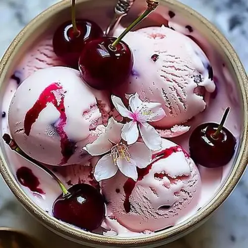 Delicious cherry blossom ice cream in a bowl, topped with fresh flowers.