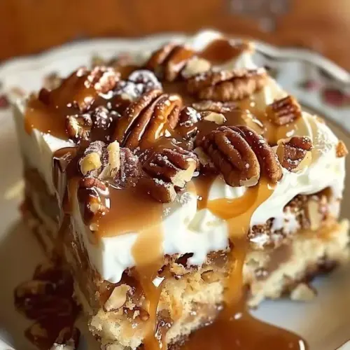 Delicious Praline Pecan Poke Cake topped with a rich praline sauce and pecans.