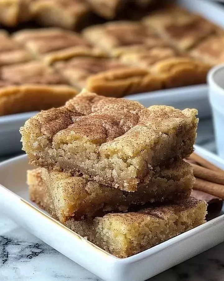 Delicious soft and chewy snickerdoodle bars on a white plate